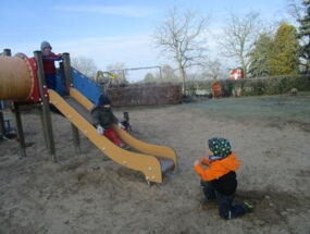 Kinder spielen draußen auf der Rutsche