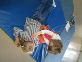 Zwei Kinder machen eine Marienkäfer-Rückenmassage
