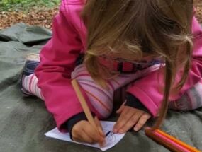 Ein Kind gestaltet ein Kürbisbuch