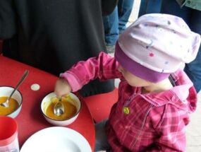 Ein Kind isst Kürbissuppe