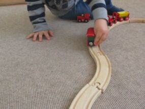 Ein Kind fährt mit der Eisenbahn über die Schiene